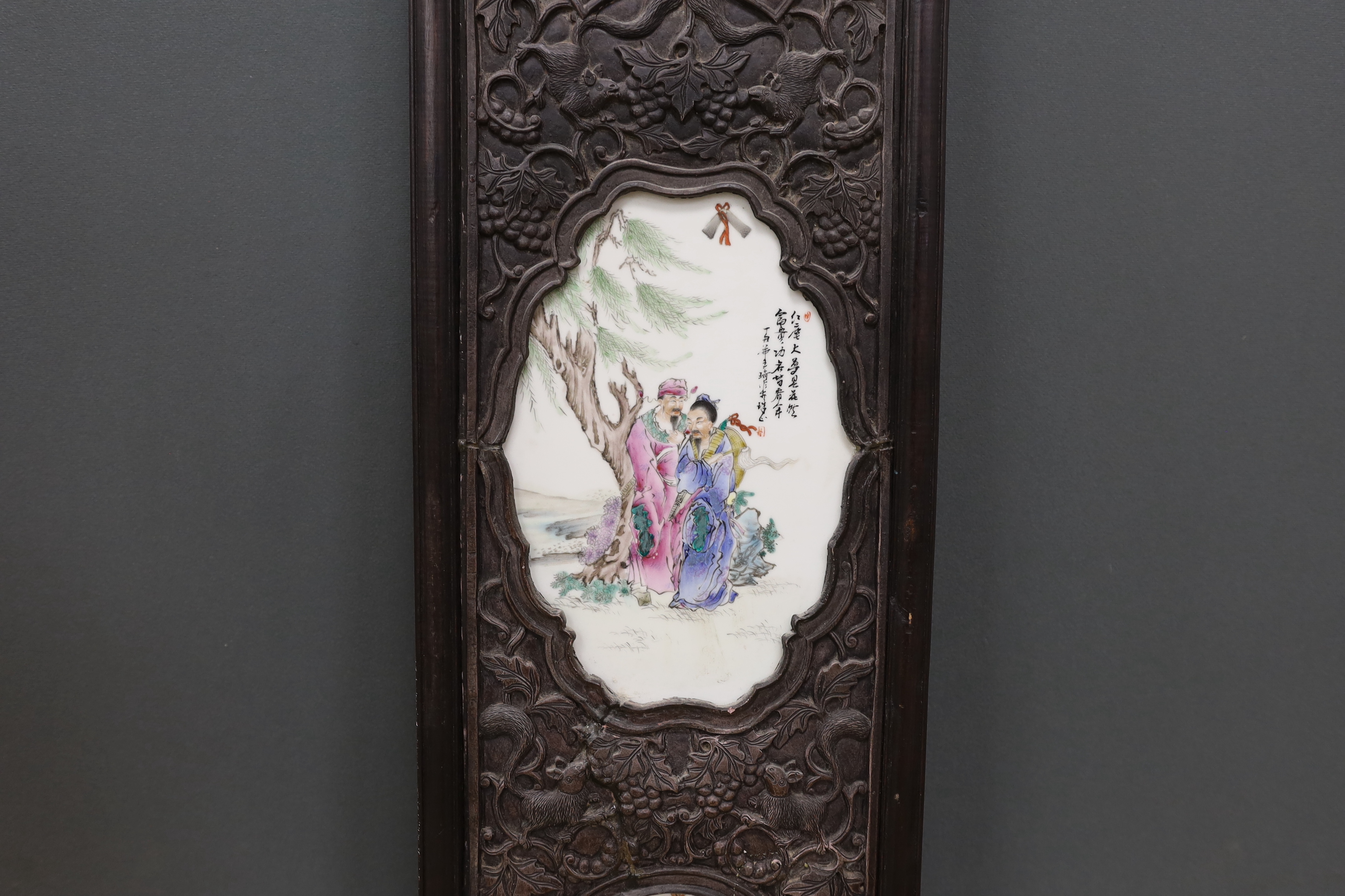 A Chinese famille rose porcelain panel, housed in a carved hardwood frame, 106cm high
